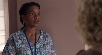 Movie still from “Grandma” (2015), directed by Paul Weitz – A woman in a blue and white floral print shirt; Close Up shot, Over the shoulder angle