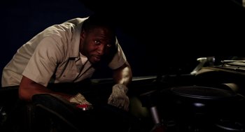 Movie still from “Grandma” (2015), directed by Paul Weitz – A man working on a car in the dark; Medium shot, Low angle