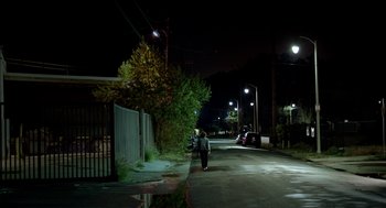 Movie still from “Grandma” (2015), directed by Paul Weitz – A person walking down a street at night; Extreme Wide shot, High angle