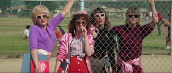 Movie still from “Grease 2” (1982), directed by Patricia Birch – A woman in a pink jacket smoking a cigarette next to another woman in a pink jacket; Medium shot, Low angle
