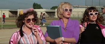 Movie still from “Grease 2” (1982), directed by Patricia Birch – Two women are standing next to each other; Medium shot, Low angle