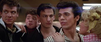 Movie still from “Grease 2” (1982), directed by Patricia Birch – A group of young men standing next to each other; Medium shot, Low angle