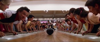 Movie still from “Grease 2” (1982), directed by Patricia Birch – A group of young men playing a game of bowling; Wide shot, High angle