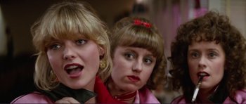 Movie still from “Grease 2” (1982), directed by Patricia Birch – Two young women are posing for a picture; Close Up shot, Low angle