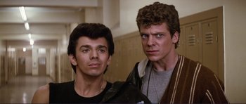 Movie still from “Grease 2” (1982), directed by Patricia Birch – Two men standing next to each other in front of a row of lockers; Close Up shot, Low angle