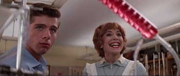 Movie still from “Grease 2” (1982), directed by Patricia Birch – A man and a woman smiling for the camera; Medium shot, Low angle