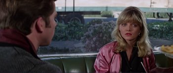 Movie still from “Grease 2” (1982), directed by Patricia Birch – Two people sitting on a green couch in a car; Medium shot, Over the shoulder angle