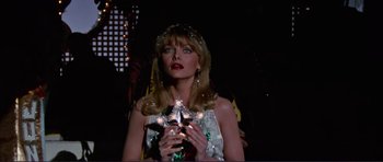 Movie still from “Grease 2” (1982), directed by Patricia Birch – A woman in a white dress holding a star in her hands; Close Up shot, Low angle