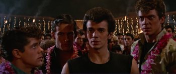 Movie still from “Grease 2” (1982), directed by Patricia Birch – A man with a black shirt is standing next to another man with a black shirt; Close Up shot, Low angle