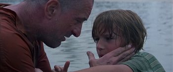 Movie still from “Great Expectations” (1998), directed by Alfonso Cuarón – A man and a little girl standing next to a body of water; Close Up shot, Over the shoulder angle