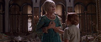 Movie still from “Great Expectations” (1998), directed by Alfonso Cuarón – An older woman in a green dress holding her hands over her chest; Medium shot, Over the shoulder angle