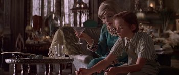 Movie still from “Great Expectations” (1998), directed by Alfonso Cuarón – A woman sitting on a couch next to a little girl; Medium shot, Over the shoulder angle