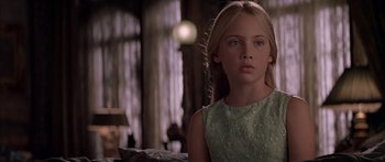 Movie still from “Great Expectations” (1998), directed by Alfonso Cuarón – A young girl in a green dress looking at the camera; Close Up shot, Over the shoulder angle