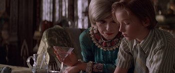 Movie still from “Great Expectations” (1998), directed by Alfonso Cuarón – A woman sitting at a table holding a glass of wine; Close Up shot, Over the shoulder angle