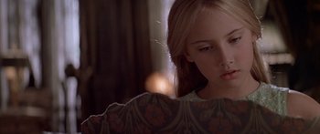 Movie still from “Great Expectations” (1998), directed by Alfonso Cuarón – A young girl looking at the camera in a dark room; Close Up shot, Over the shoulder angle