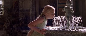 Movie still from “Great Expectations” (1998), directed by Alfonso Cuarón – A little girl in a green dress is drinking water from a fountain; Medium shot, Over the shoulder angle
