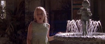 Movie still from “Great Expectations” (1998), directed by Alfonso Cuarón – A little girl in a green dress standing in front of a fountain; Medium shot, Over the shoulder angle