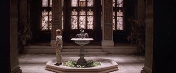 Movie still from “Great Expectations” (1998), directed by Alfonso Cuarón – A boy standing in front of a fountain in a building; Wide shot, High angle