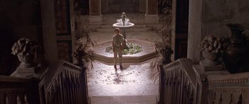 Movie still from “Great Expectations” (1998), directed by Alfonso Cuarón – A man standing in front of a water fountain; Wide shot, High angle
