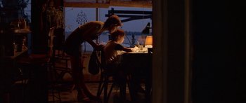 Movie still from “Great Expectations” (1998), directed by Alfonso Cuarón – A woman and a child at a table with a lamp; Wide shot, Over the shoulder angle