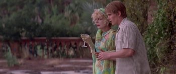 Movie still from “Great Expectations” (1998), directed by Alfonso Cuarón – A man and a woman standing next to each other holding wine glasses; Medium shot, Over the shoulder angle