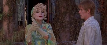 Movie still from “Great Expectations” (1998), directed by Alfonso Cuarón – An older woman with blonde curly hair wearing a dress and gloves; Close Up shot, Low angle