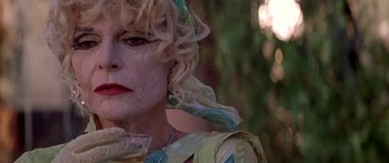 Movie still from “Great Expectations” (1998), directed by Alfonso Cuarón – An older woman with blonde curly hair wearing a green dress; Close Up shot, Low angle