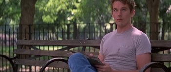 Movie still from “Great Expectations” (1998), directed by Alfonso Cuarón – A man sitting on top of a wooden park bench; Medium shot, Over the shoulder angle