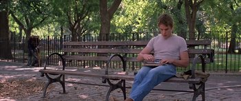 Movie still from “Great Expectations” (1998), directed by Alfonso Cuarón – A man sitting on top of a wooden park bench; Medium shot, Over the shoulder angle