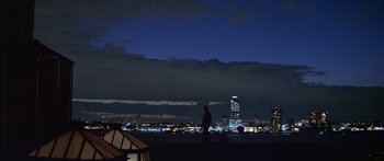 Movie still from “Great Expectations” (1998), directed by Alfonso Cuarón – A man standing on top of a building at night; Extreme Wide shot, Low angle