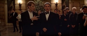 Movie still from “Great Expectations” (1998), directed by Alfonso Cuarón – Two young men in tuxedos talking in front of a crowd; Medium shot, Low angle