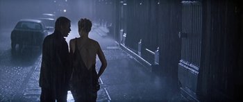 Movie still from “Great Expectations” (1998), directed by Alfonso Cuarón – Two people walking down the street in the rain; Wide shot, Low angle