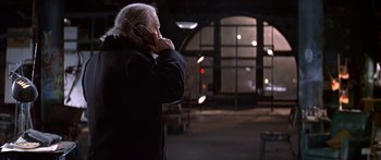 Movie still from “Great Expectations” (1998), directed by Alfonso Cuarón – An older man talking on a cell phone while standing outside; Medium shot, Over the shoulder angle