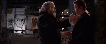 Movie still from “Great Expectations” (1998), directed by Alfonso Cuarón – A man with a long white beard is talking to another man in a black suit; Medium shot, Over the shoulder angle