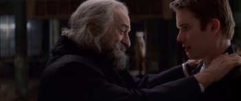 Movie still from “Great Expectations” (1998), directed by Alfonso Cuarón – An old man with a beard is sitting in a chair; Close Up shot, Over the shoulder angle