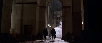 Movie still from “Great Expectations” (1998), directed by Alfonso Cuarón – Two people are walking through an archway at night; Wide shot, Low angle
