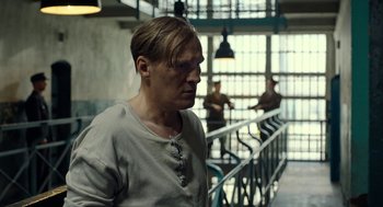 Movie still from “Great Freedom” (2021), directed by Sebastian Meise – A man standing in front of a railing in a jail cell; Medium shot, Over the shoulder angle