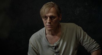 Movie still from “Great Freedom” (2021), directed by Sebastian Meise – A man in a white shirt is looking at the camera; Close Up shot, Over the shoulder angle