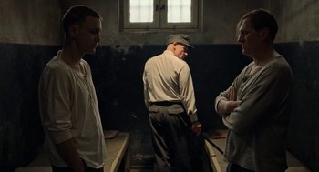 Movie still from “Great Freedom” (2021), directed by Sebastian Meise – A group of men standing next to each other in a room; Medium shot, Over the shoulder angle