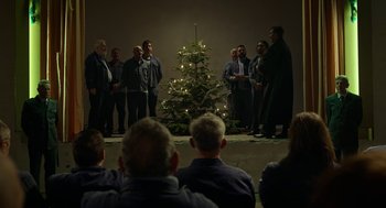 Movie still from “Great Freedom” (2021), directed by Sebastian Meise – A group of men standing around a christmas tree; Wide shot, Low angle