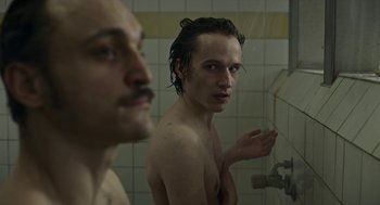 Movie still from “Great Freedom” (2021), directed by Sebastian Meise – A man taking a selfie in the shower with another man; Close Up shot, Over the shoulder angle
