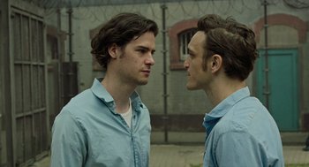Movie still from “Great Freedom” (2021), directed by Sebastian Meise – Two men standing next to each other in front of a building; Close Up shot, Over the shoulder angle