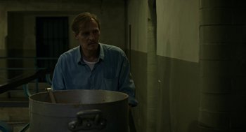 Movie still from “Great Freedom” (2021), directed by Sebastian Meise – A man standing in front of a large metal pot; Medium shot, Low angle