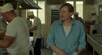 Movie still from “Great Freedom” (2021), directed by Sebastian Meise – A man standing in a kitchen next to other cooks; Medium shot, Over the shoulder angle