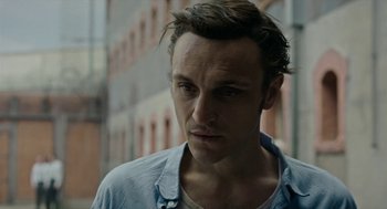 Movie still from “Great Freedom” (2021), directed by Sebastian Meise – A person wearing a blue shirt; Close Up shot, Over the shoulder angle