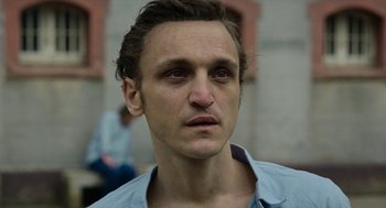 Movie still from “Great Freedom” (2021), directed by Sebastian Meise – A person wearing a blue shirt; Close Up shot, Low angle