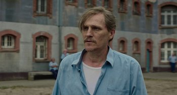 Movie still from “Great Freedom” (2021), directed by Sebastian Meise – A person wearing a blue shirt; Close Up shot, Over the shoulder angle