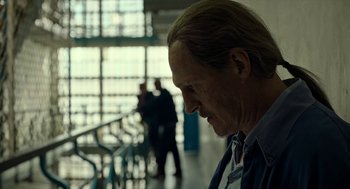 Movie still from “Great Freedom” (2021), directed by Sebastian Meise – A man with long blonde hair wearing a tie; Close Up shot, Low angle