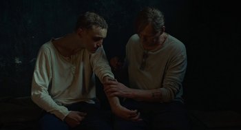 Movie still from “Great Freedom” (2021), directed by Sebastian Meise – Two men sitting next to each other in a dark room; Medium shot, High angle