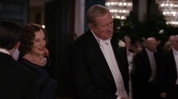 Movie still from “Grey Gardens” (2009), directed by Michael Sucsy – A man in a tuxedo standing next to a woman in a black dress; Medium shot, Over the shoulder angle